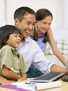 Father with son and daughter at a computer